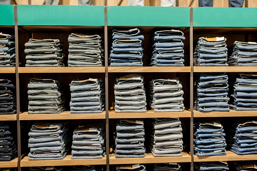 Jeans pants on the store shelf. Blue jeans denim Collection jeans stacked.